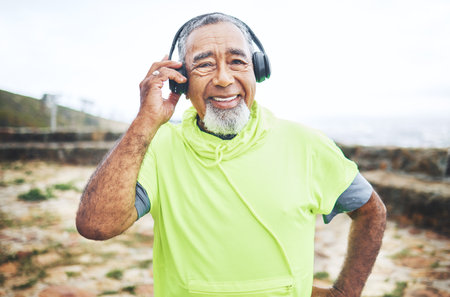 Happy, headphones and senior man hiking and listening to music, playlist or album for cardio workout. Smile, nature and portrait of elderly male person streaming a song for outdoor trekking in woods.の写真素材
