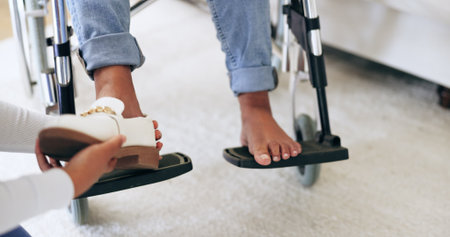 Caregiver, help and shoes of patient in wheelchair, healthcare and assistance in nursing home....