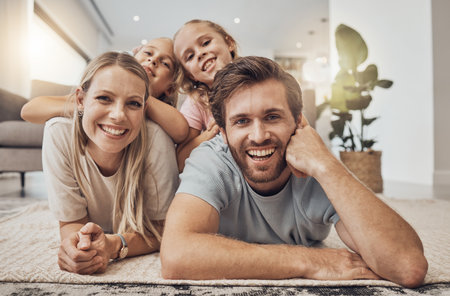 Home, portrait and family with girls on the floor, relax and happiness with joy, cheerful and weekend break. Children, mother or father with kids on the ground, calm or care with a smile in a loungeの写真素材