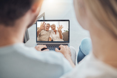 Laptop, wave and senior couple on video call, online meeting and communication webinar. Computer, hello and elderly man and woman in virtual conference, internet chat and talking in retirement homeの写真素材
