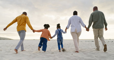 Happy, love and holding hands with black family at beach for summer, vacation and relax. Holiday, support and travel with parents and children walking on coastline for care, trust and freedomの写真素材