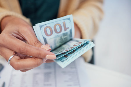 Hands, finance and a business person counting money closeup in the office of a bank for accounting....