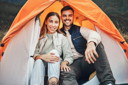 Couple, tent and camping in portrait, smile and happy for holiday, nature and morning in countryside. Man, woman and relax outdoor with vacation, glamping and adventure with love, bonding and freedomの写真素材