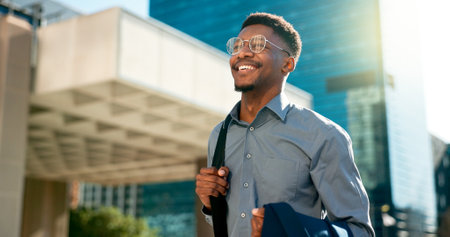 Business, happy and walking black man on city journey, commute trip and realtor smile on way to office building. Happiness, career expert and African real estate agent on morning travel in Nigeriaの写真素材