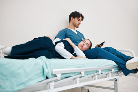 Tired, nurses and relax on break in hospital or sleeping on bed in clinic with friends, fatigue and support. Reading, phone and care for mental health in healthcare with doctors or medical staffの写真素材