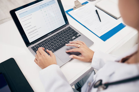 Laptop, hands or doctor with research, medical update or telehealth web service in hospital clinic....