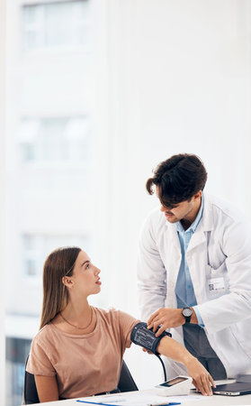 Doctor, woman and blood pressure machine for healthcare, health assessment or check up at hospital....