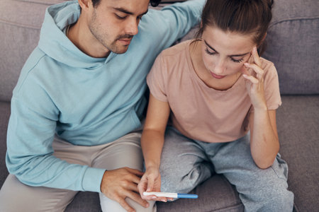 Couple, pregnancy test and stress on sofa infertility, anxiety or support man. Woman, or male person or frustrated ovulation news or waiting information fear for loss, relationship problem or comfortの写真素材
