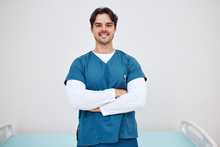 Portrait, doctor and arms crossed for smile in space for health, treatment or wellness. Happy man, nurse and scrubs for career in medicine with emergency care, cardiology or rehabilitation in clinicの写真素材