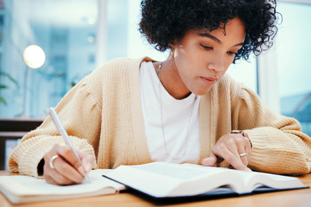 Bible, study and writing, woman with notes on religion at desk in home, Christian faith and...