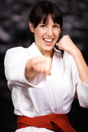 Woman, karate and punch in portrait, fight and self defense sport with muay thai and training. Athlete, combat and power with fitness, martial arts and energy with warrior, exercise and taekwondoの写真素材