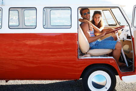 Caravan, transport and couple on road trip, travel and vacation with portrait of people in relationship. Happiness, freedom and together on adventure with transportation, anniversary date and hugの写真素材