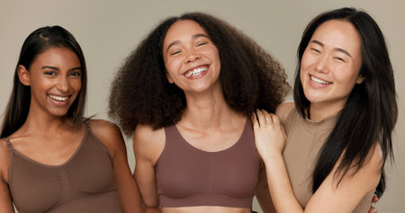 Diversity, underwear and portrait of women friends in studio for beauty, inclusion or wellness. Happy people hug on neutral background as different body care, skin glow or natural cosmetic comparisonの写真素材