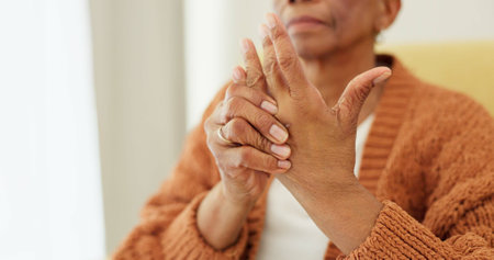 Hands, pain and arthritis with an elderly woman in her nursing home, struggling with a medical injury or problem. Healthcare, ache or carpal tunnel with a senior resident in an assisted living houseの写真素材