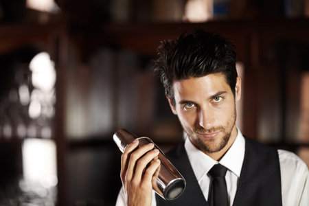 Shake, cocktail and portrait of bartender with a drink for customer in dark club or night. Mixing, alcohol and face of barman with liquor in metal container or shaker for a strong beverage in a barの写真素材
