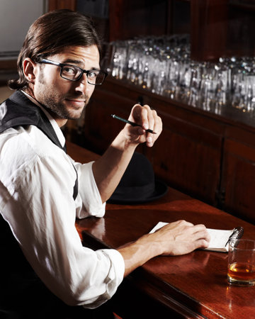 Portrait, writer and man with a notebook, whiskey and creativity with inspiration, journalist and glasses. Face, person and author with alcohol, ideas and writing in a tavern, poet and freelancerの写真素材