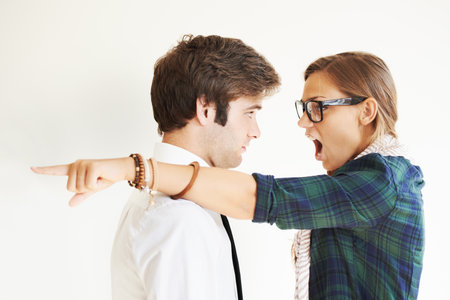 Couple, screaming and fight, divorce and pointing in studio isolated on white background. Woman shout, breakup and man frustrated, angry at relationship fail or cheating, stress and marriage conflictの写真素材