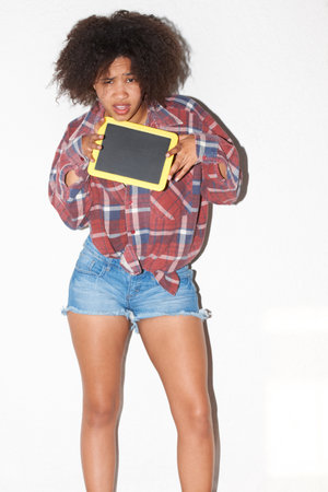 Space, blackboard and portrait of a black woman on a studio background for marketing or information. Crazy, poster and an african girl with a chalkboard for advertising, message or mockup signの写真素材
