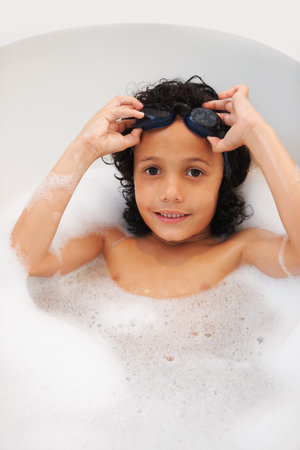 Portrait, kids and bath with a boy in goggles while cleaning his skin in the home for natural...