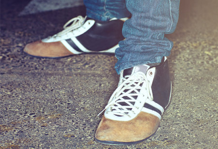 Closeup, person and feet with shoes for fashion, vintage style or aesthetic in road for lifestyle or trend. Ground, legs and flats for creativity, retro or unique footwear in street on backgroundの写真素材