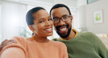 Black couple, selfie and home with love, support and care together on a living room sofa with smile. Date, portrait and happy people in the morning with communication and bonding with social mediaの写真素材