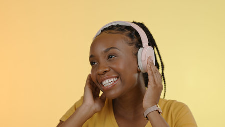 Smile, headphones and black woman with a smartphone, listening and excited on a yellow studio...