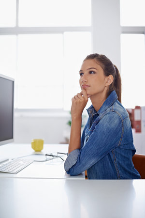 If you can dream it, you can do it. a woman sitting thoughtfully at her work station.