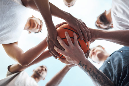 One team, one dream. Closeup shot of a group of sporty young men huddled around a basketball on a...