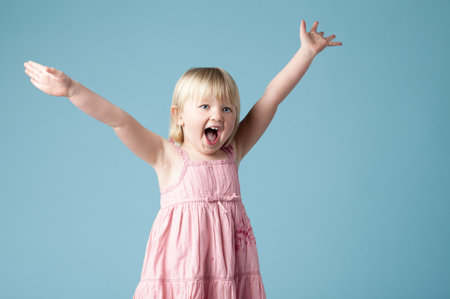 Her excitement fills the room. an excited little girl against a studio background.の写真素材