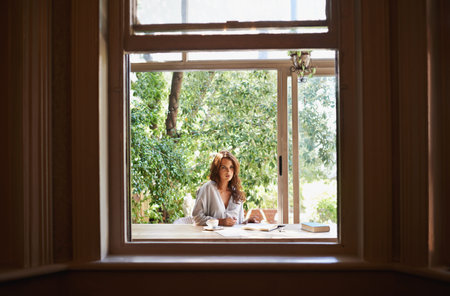 Searching for inspiration in the summer sun. an attractive young woman writing in a relaxed...