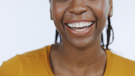 Black woman, mouth and teeth with smile for dental, healthcare and happiness with hygiene on white background. Closeup for oral care, orthodontics and fresh breath, clean and wellness in studioの写真素材