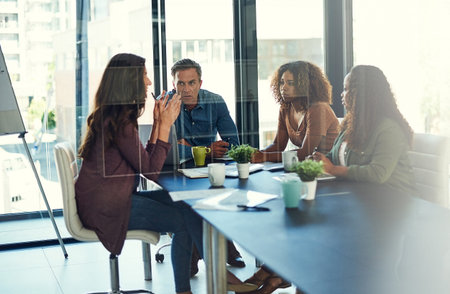 Laying out all their ideas on the table. a group of businesspeople having a meeting in an office.