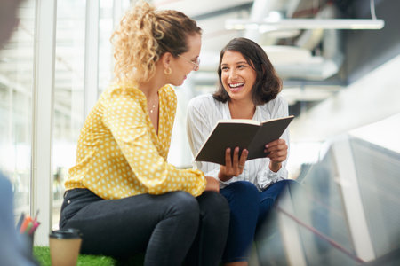 Get ready to meet your goals. two young businesswomen having a discussion in a modern office.の写真素材