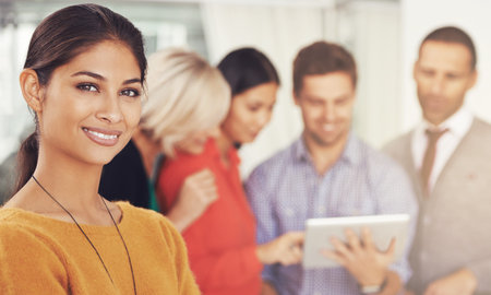 Ive got a great team behind me. Cropped portrait of a young businesswoman standing in an office with...