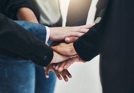 This is to our team. a group of unrecognizable businesspeople forming a huddle with their hands at...
