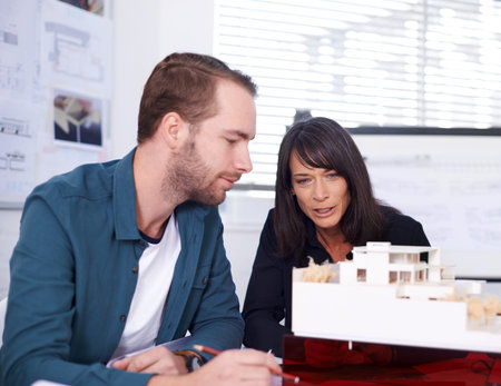 I think it looks great. Two architects in working on a model of a house.