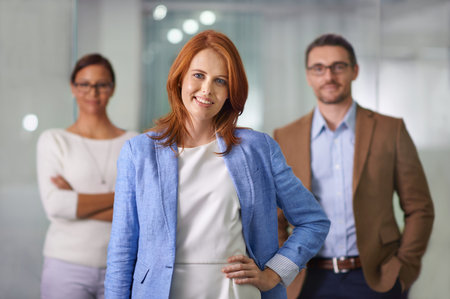 We believe in teamwork. Portrait of a young businesswoman standing in front of her colleagues.