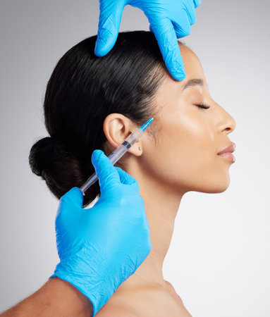 Closeup of a gorgeous mixed race woman getting botox filler. Hispanic model getting filler to reduce...
