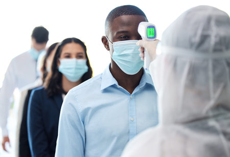 Lets check your temperature. a group of businesspeople standing in a line to get their temperatures...