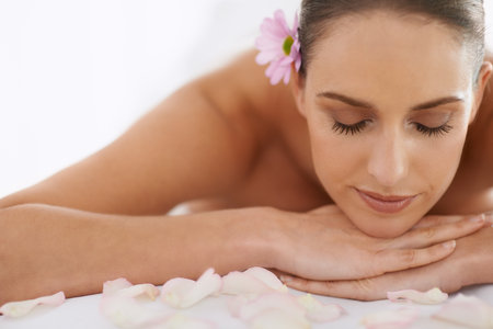 Taking care of her inner girl. Closeup of a beautiful young woman lying on a massage table.の写真素材