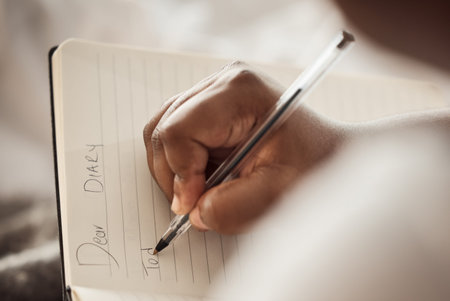 Woman hands, notebook and writing in diary for mental health, self care and creative inspiration....
