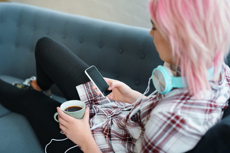 Relax, coffee and a woman with a phone for music, social media or communication on the sofa....