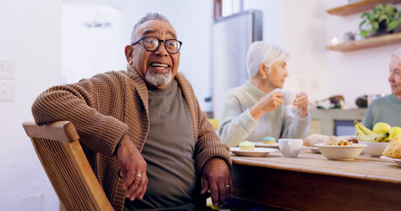 Retirement, tea party and a group of senior people in the living room of a community home for a social. Friends, smile or conversation with elderly men and women together in an apartment for a visitの写真素材