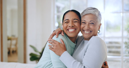 Hug, happy and portrait of mother and daughter in home for bonding, relationship and smile together. Family, love and mature mom embrace adult woman for mothers day, support and care in living roomの写真素材