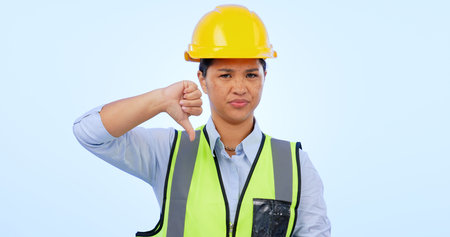 Woman, thumbs down and engineer for construction by architect in studio by blue background. Asian...