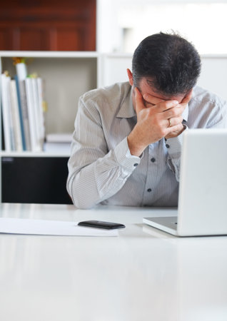 Businessman, laptop and stress or depression at office, tired and fatigue for technology. Mature...