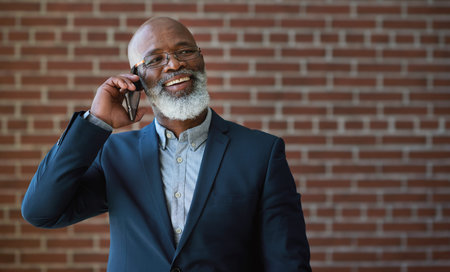 Phone call of senior black man on brick wall for business communication, networking success or news. Happy professional manager, USA executive or boss talking on smartphone for investment opportunityの写真素材