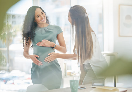 Thank you for supporting my at work through my pregnancy. a businesswoman touching her colleagues...