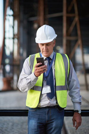 Construction, engineer and man with a phone outdoor for building project management contact....