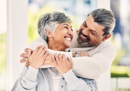Hug, home and senior couple with love, smile and retirement with happiness, quality time or loving together. Old woman, happy mature man or embrace in a lounge, bonding or romance with a relationshipの写真素材